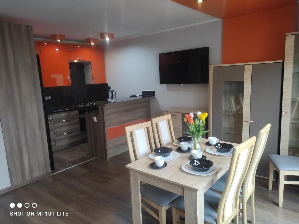 a kitchen and dining room with a table and chairs at Apartament u Sylvie in Siedlce