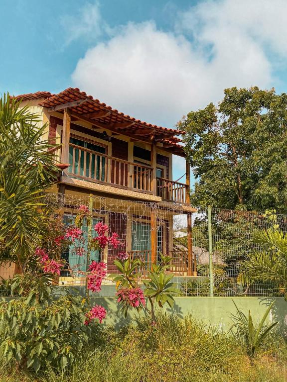a house with a deck and flowers in the yard at Suites Vossoroca in Alto Paraíso de Goiás