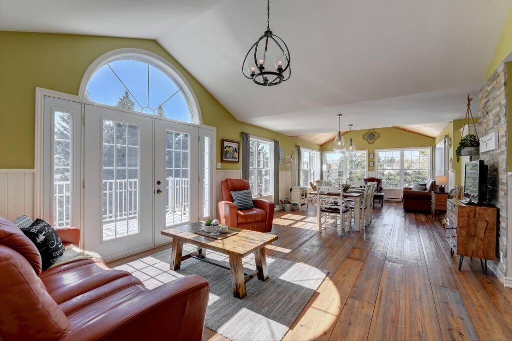 un salon avec un canapé et une table dans l'établissement Stunning Waterfront Chalet A Lot Of Natural Light, à Saint-Zénon