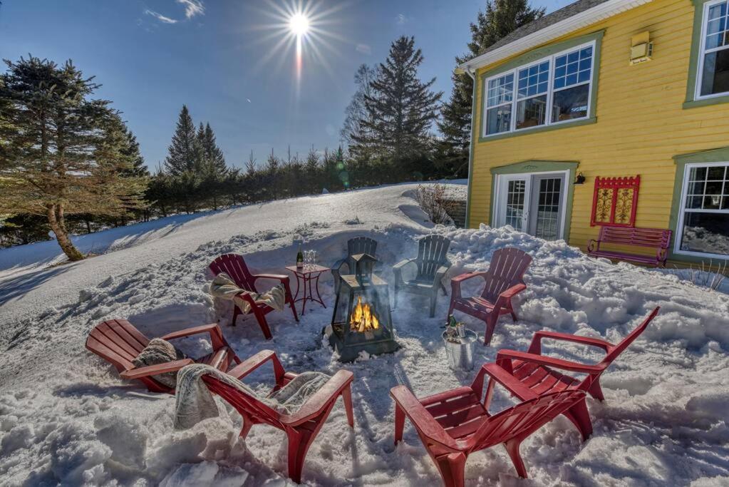 a fire pit in the snow in front of a house at Stunning Waterfront Chalet A Lot Of Natural Light in Saint Zenon