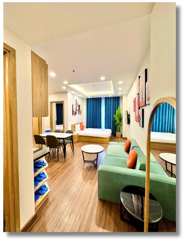 a living room with a green couch and a table at FLC Luxury Apartment Quy Nhon in Quy Nhon