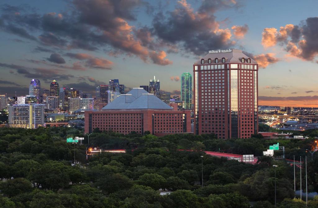 Blick auf die Skyline der Stadt mit einem hohen Gebäude in der Unterkunft Hilton Anatole in Dallas