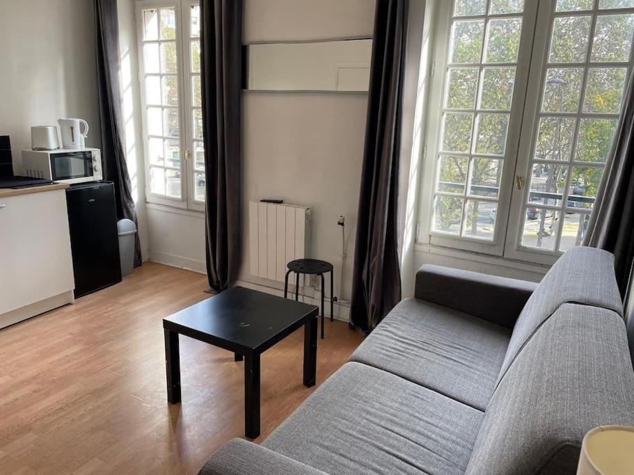 ein Wohnzimmer mit einem Sofa und einem Couchtisch in der Unterkunft Studio Paris 14 in Paris