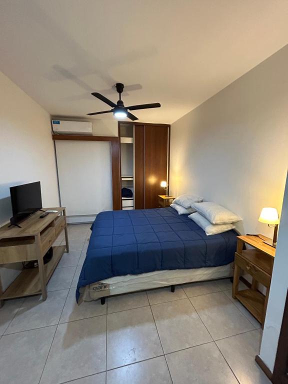 a bedroom with a blue bed and a ceiling fan at Consorcio San Ignacio in San Juan