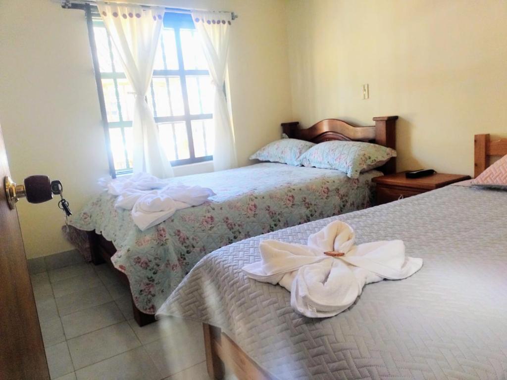 1 dormitorio con 2 camas con flores blancas en ABI HAPPY, en Villa de Leyva