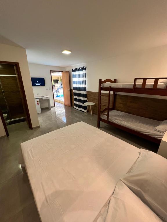 um quarto com 2 beliches e uma sala de estar em Pousada Amoré em Porto de Galinhas, PE em Porto de Galinhas