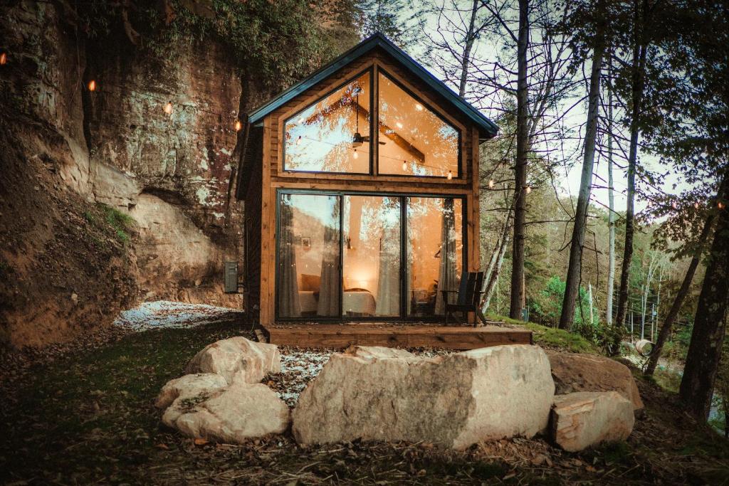 uma casa de vidro no meio de uma floresta em Tiny Cabin in RRG - The Taoist em Rogers