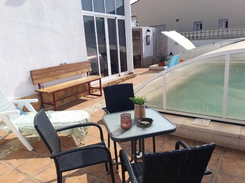 un patio con mesa y sillas y una piscina en La casa de huespedes, en Puebla de Vallbona