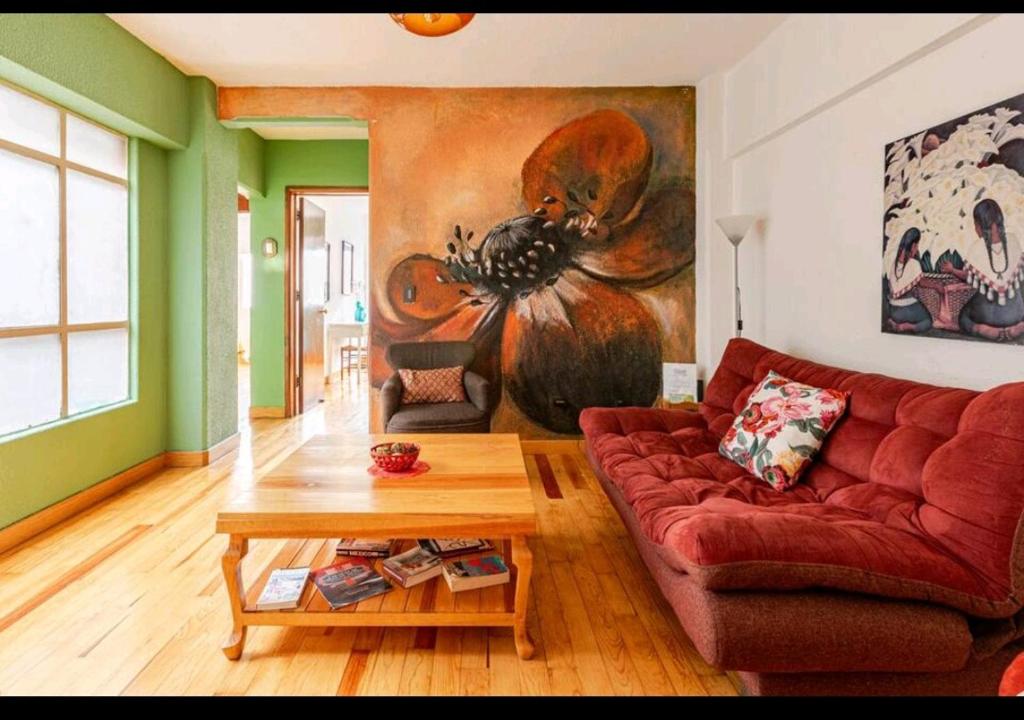 sala de estar con sofá rojo y mesa en Departamento Mural Artístico, en Ciudad de México