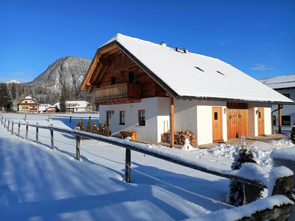 un bâtiment avec une clôture dans la neige dans l'établissement Wolfgangchalet B, à Mauterndorf