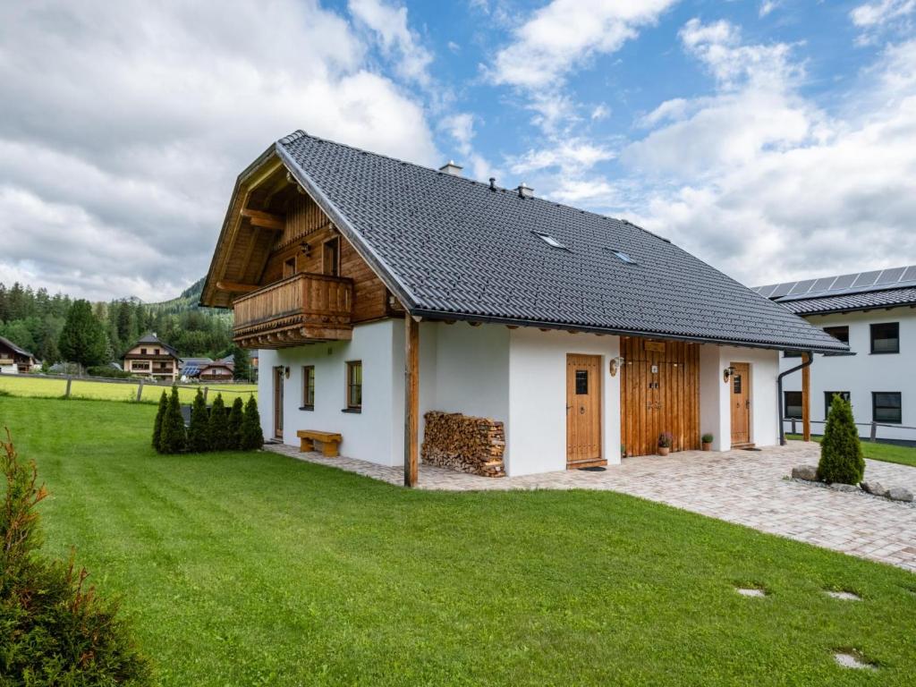 a house with a gambrel roof and a green yard at Wolfgangchalet C in Mauterndorf