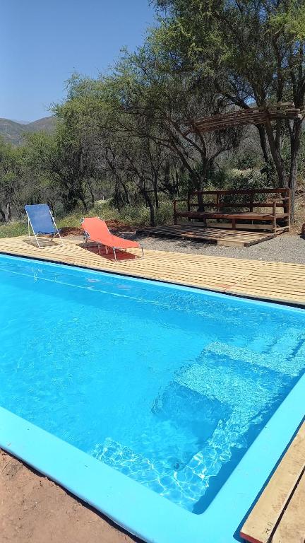 una piscina azul con banco y silla en Casavistacolliguay, 