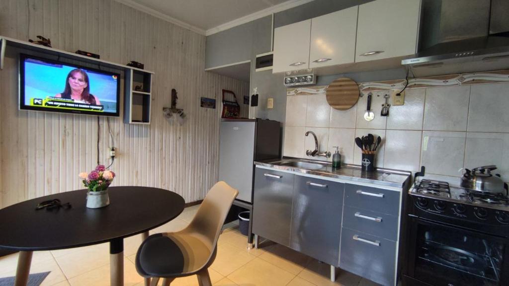 uma cozinha com uma mesa e uma televisão na parede em Apartamento RE real de San Carlos em Colônia do Sacramento