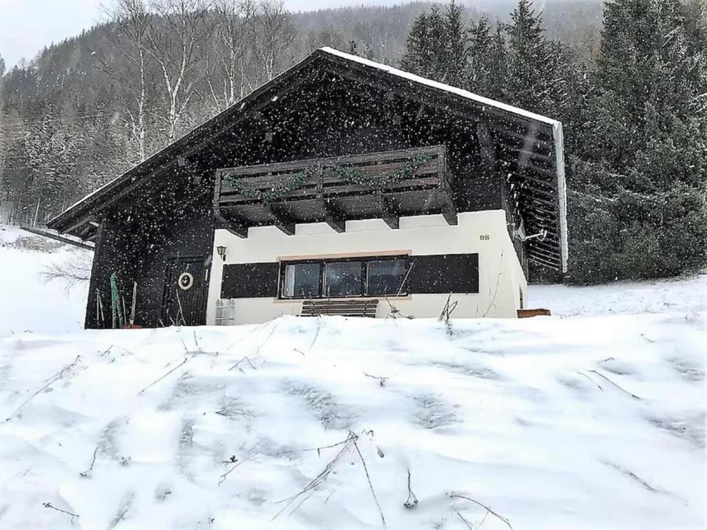 Un edificio nella neve con la neve che ci cade sopra di Jagerhütte a Mallnitz