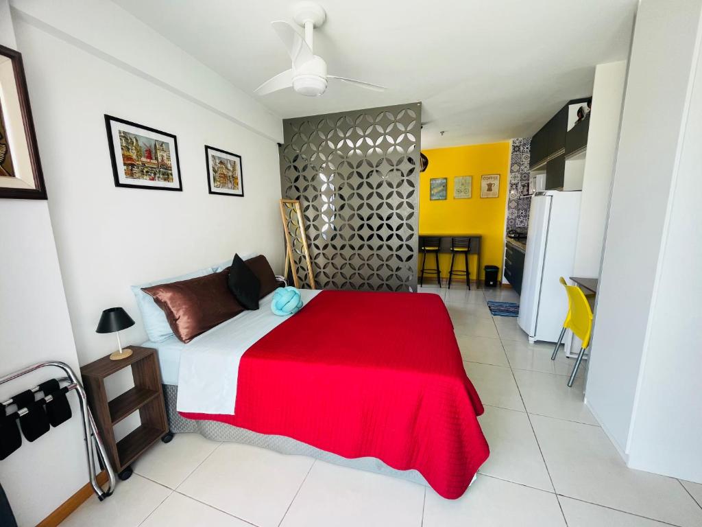 a bedroom with a bed with a red blanket at Loft london, estilo e praticidade no coração de Icarai in Niterói