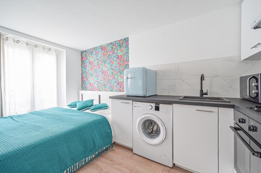 a bedroom with a bed and a washing machine at Studio Cosy 2/4P - République in Paris