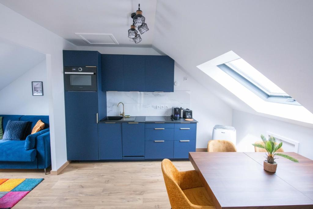 uma cozinha com armários azuis e uma mesa de jantar em Le Champs-Elysees - Cité universitaire Paris 14 em Gentilly
