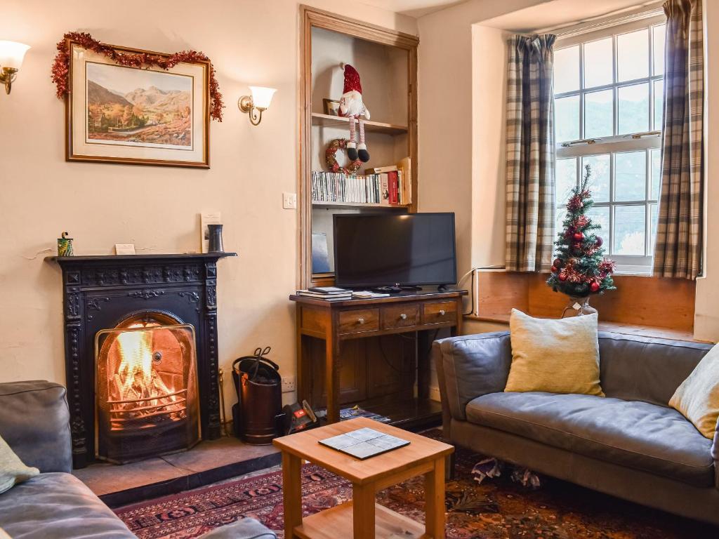 a living room with a fireplace and a christmas tree at Lingmoor View in Ambleside