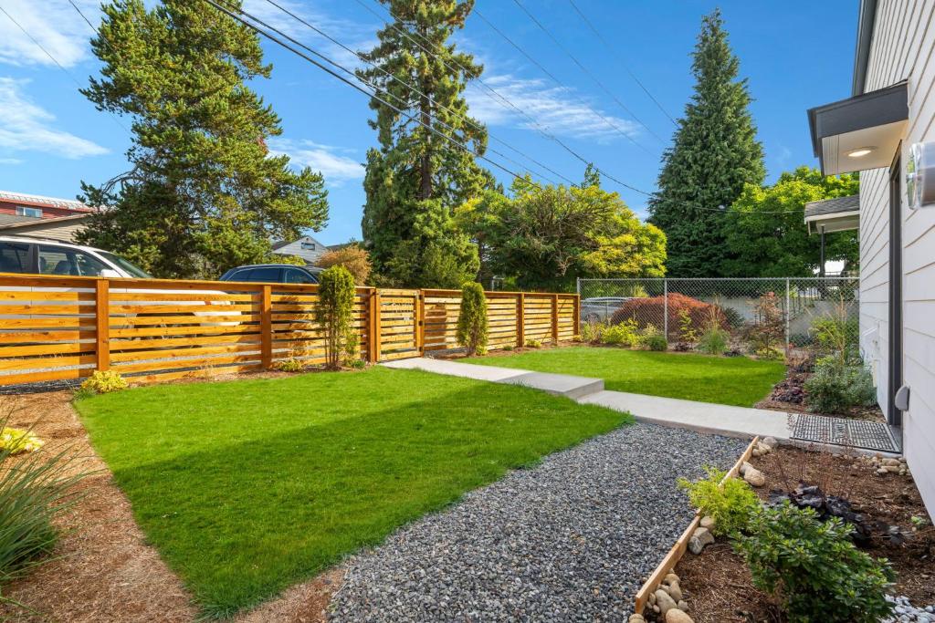 a backyard with a wooden fence and grass at Brand New Home 10min To Green Lake in Seattle