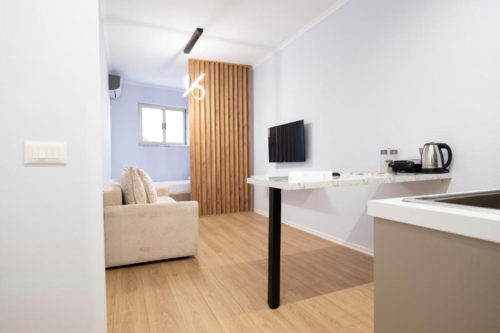 een keuken en een woonkamer met een tafel en een stoel bij Trio Apartment's City Center Tirana in Tirana