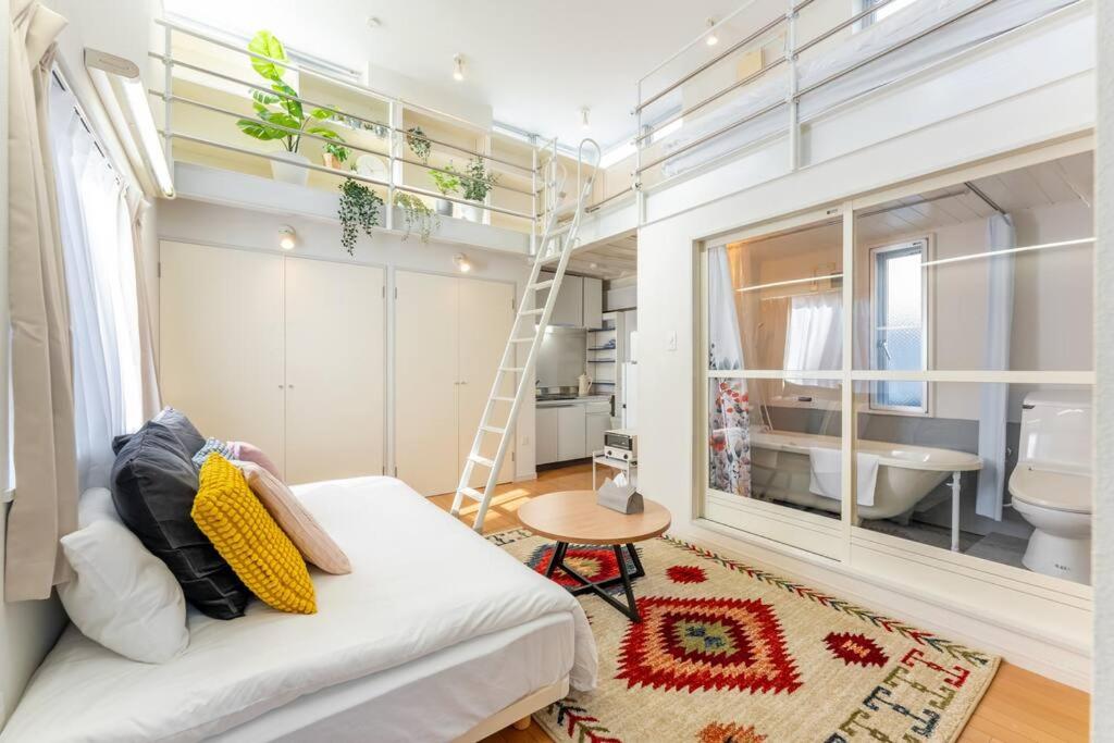 a living room with a white couch and a bathroom at M'sHouse in Tokyo
