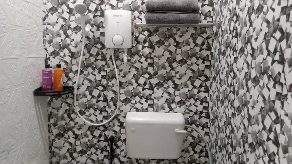 a bathroom with a black and white patterned wall at Nur Aisyah homestay kemaman..3 bedrooms in Kampong Kemaman