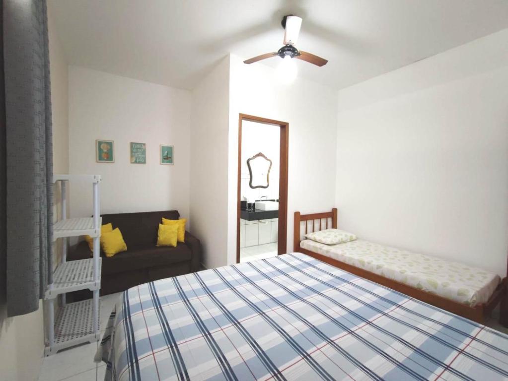 1 dormitorio con 1 cama y 1 sofá en Apartamento em Ilha bela, en Ilhabela