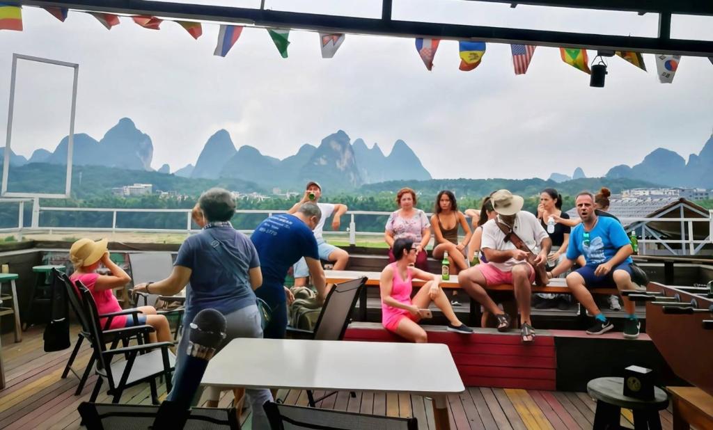 a group of people sitting on the deck of a boat at Showbiz Hostel in Yangshuo