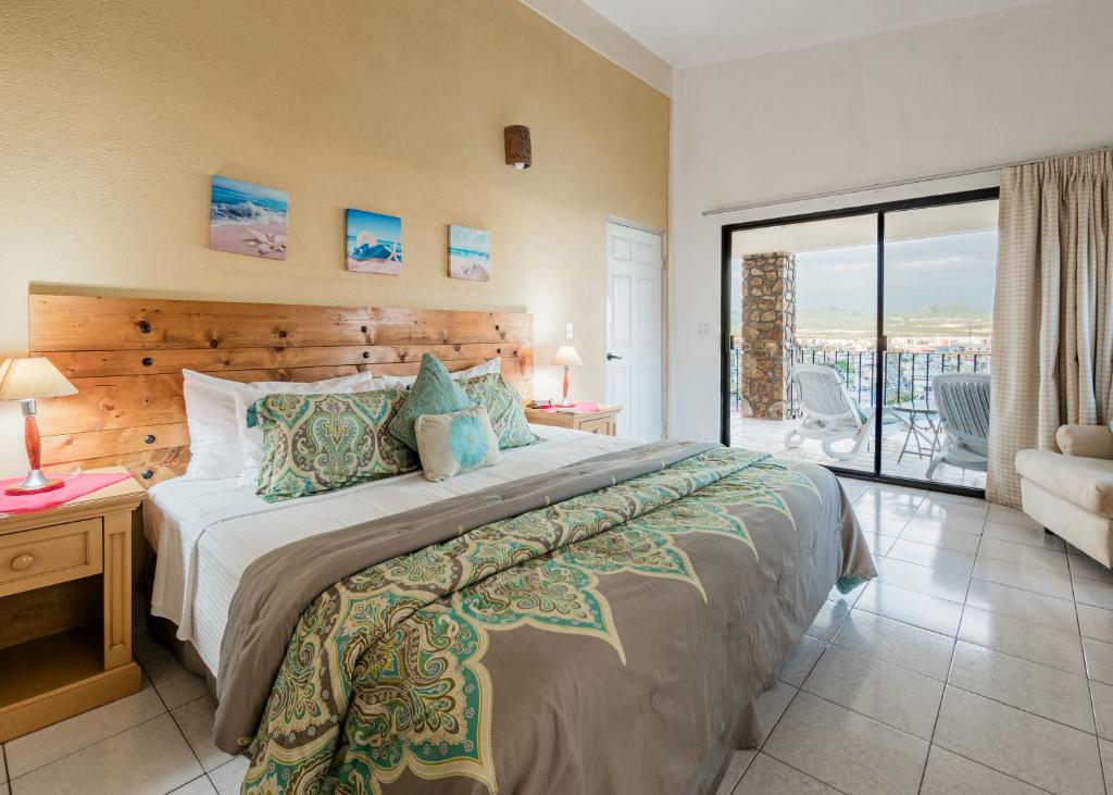 een slaapkamer met een groot bed en een balkon bij Marina View Villas in Cabo San Lucas