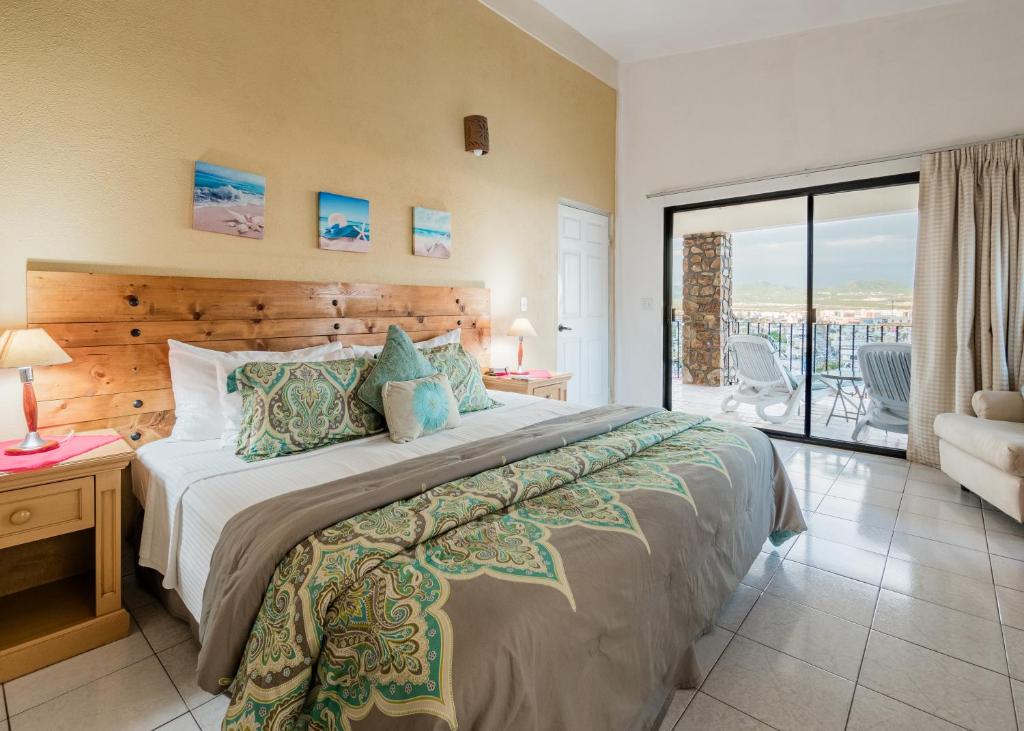 um quarto com uma cama grande e uma varanda em Marina View Villas em Cabo San Lucas