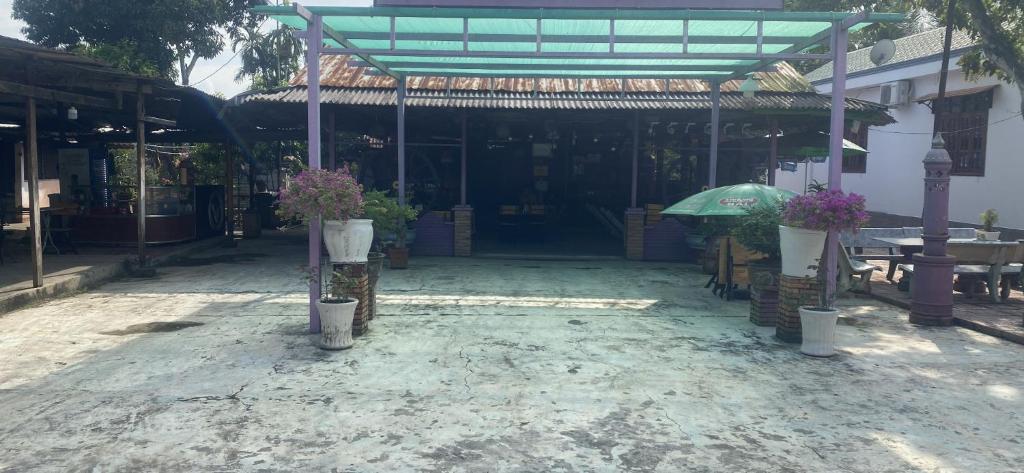 ein Gebäude mit einer Terrasse mit Blumen und einem Sonnenschirm in der Unterkunft Ba Hung homestay in Ấp Hòa Phú (2)