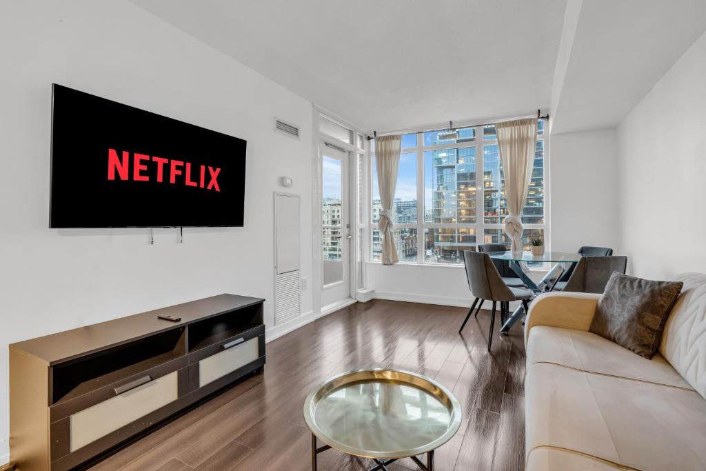 sala de estar con TV y sofá en Cityplace Luxury suites en Toronto