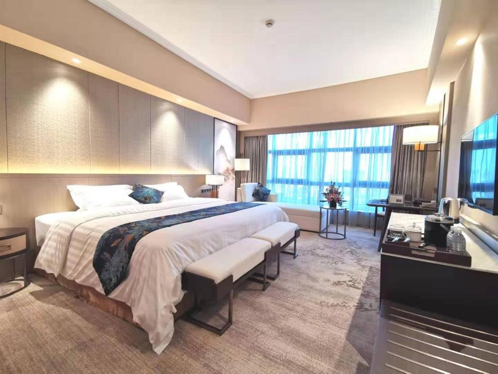 Postel nebo postele na pokoji v ubytování Jin Jiang Pine City Hotel