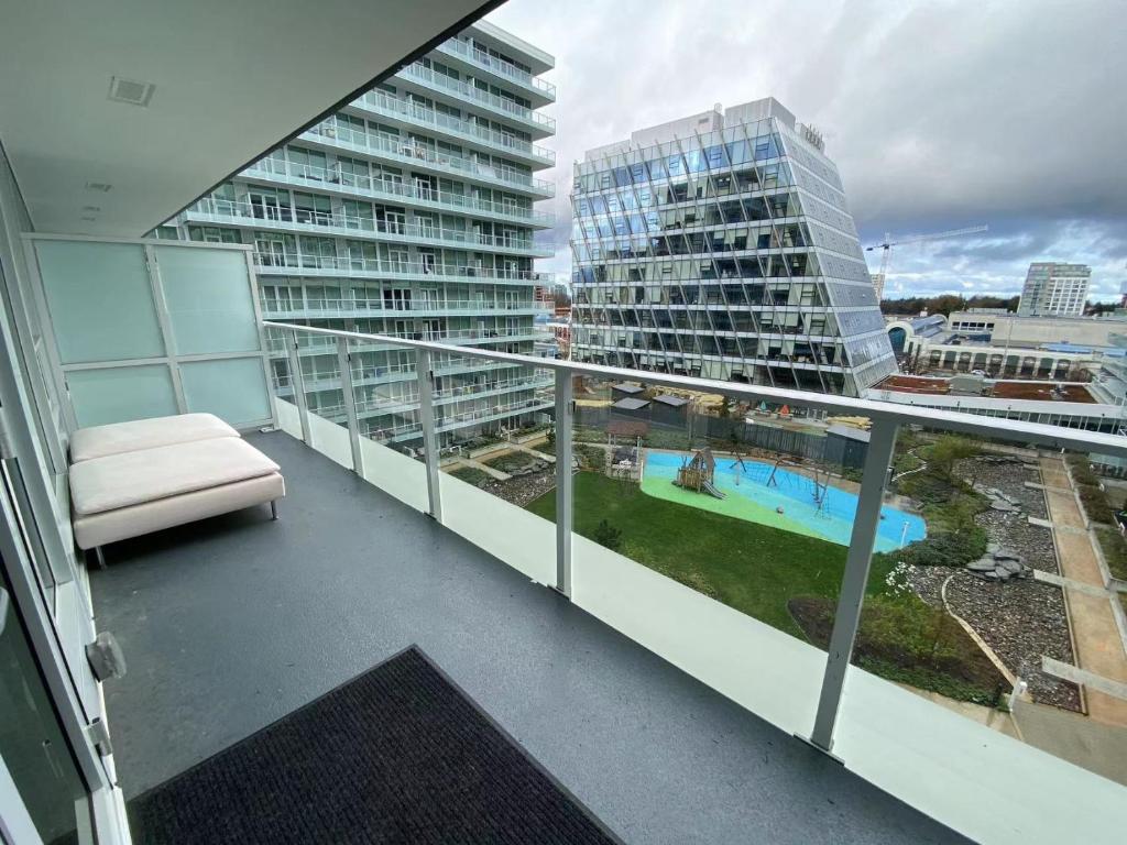 - un balcon avec un canapé et un grand bâtiment dans l'établissement Richmond center apartment, à Richmond