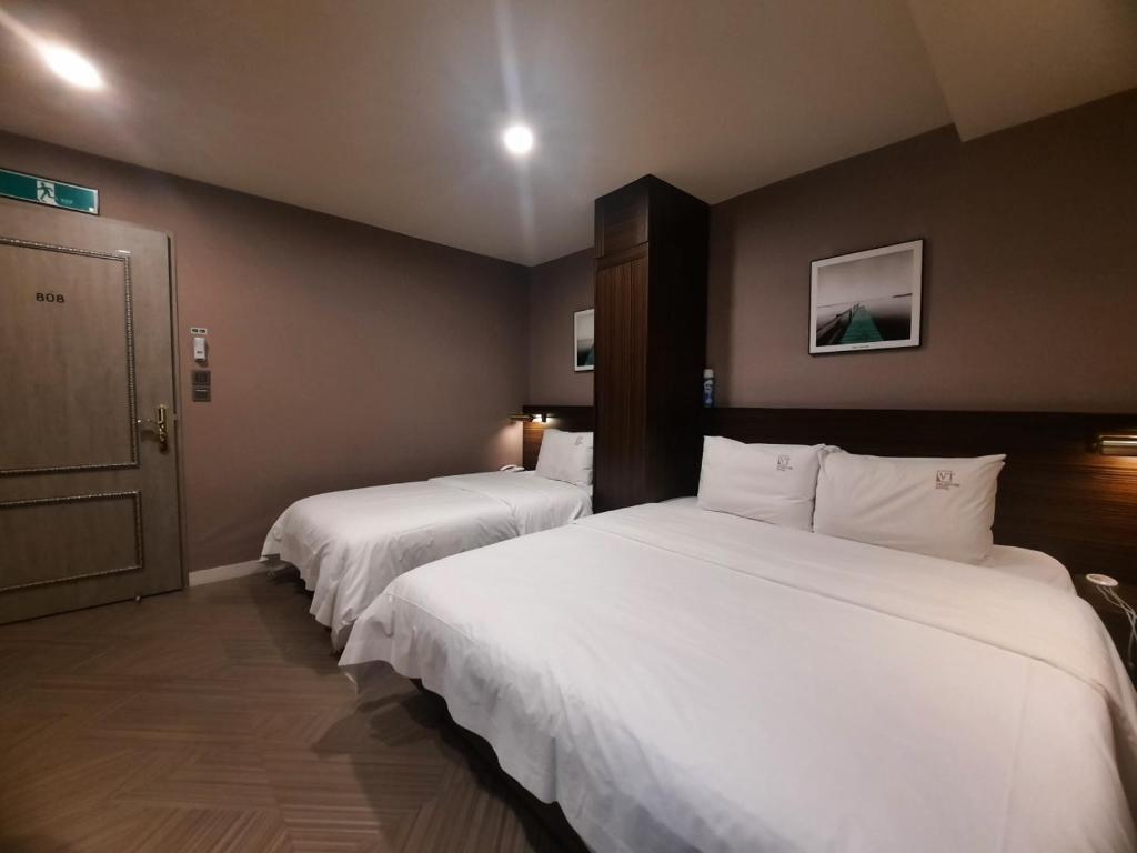 Postel nebo postele na pokoji v ubytování H Moment Hotel