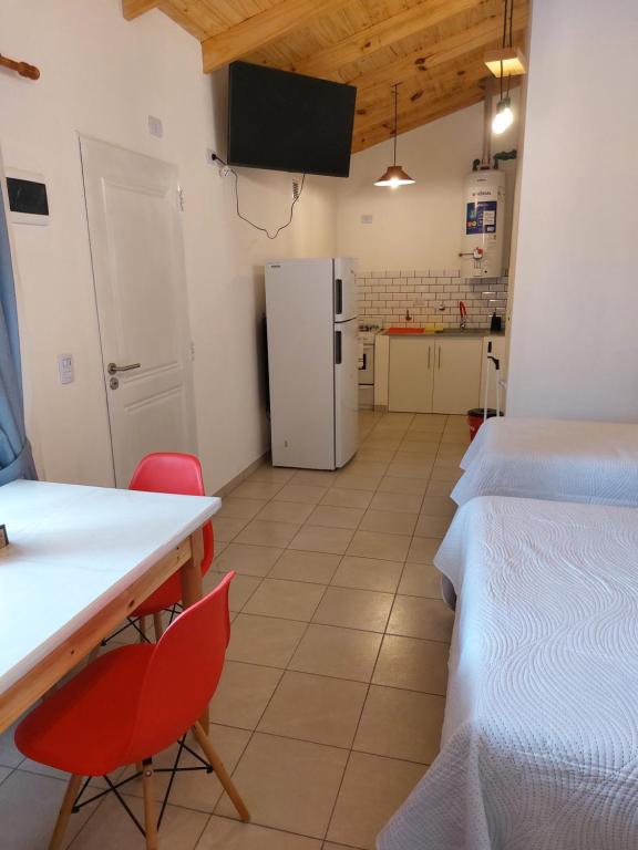 um quarto com 2 camas, uma mesa e um frigorífico em G&D Departamentos em Puerto San Julian