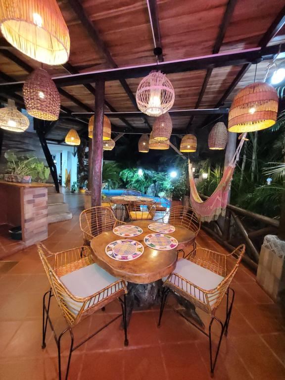 a dining room with a table and chairs and chandeliers at Hostal Antawara Tayrona in El Zaino