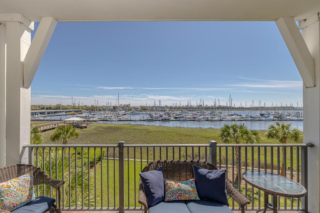 a balcony with a table and chairs and a view of a marina at Marina Retreat in Saint Simons Island