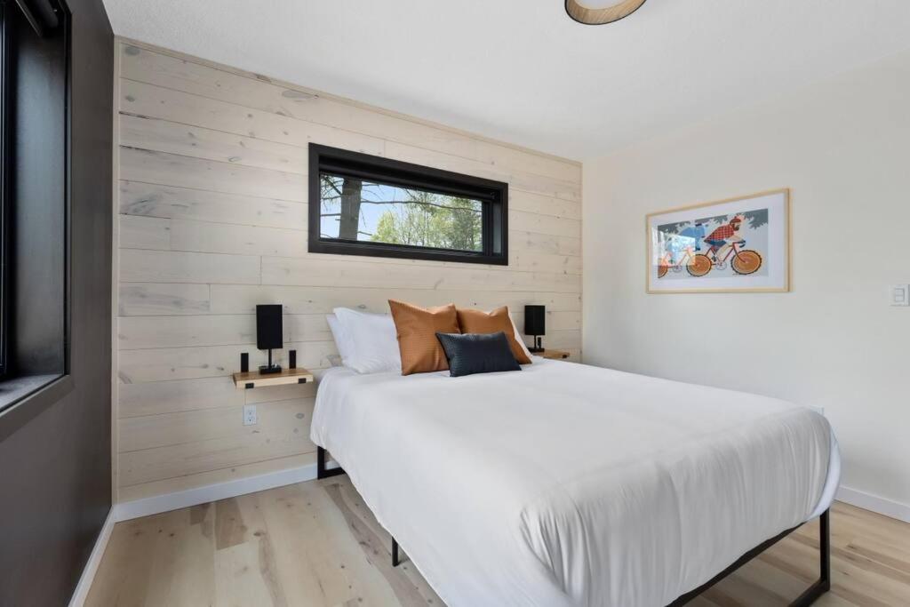 a bedroom with a large white bed and a window at Cuyuna Adventure Cabin: Solo Stove - On Bike Trail in Crosby