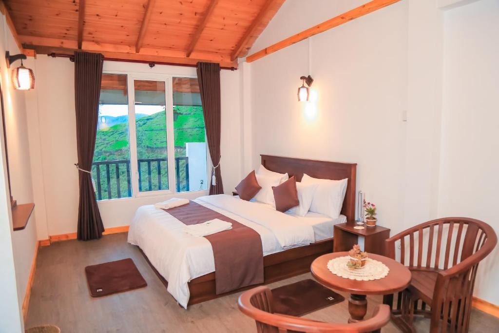 a bedroom with a bed and a table and a window at The Mount View Single Tree Hotel in Nuwara Eliya