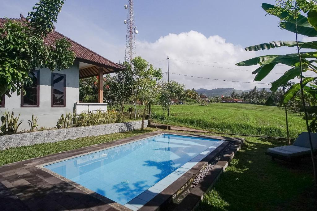 a swimming pool in the yard of a house at Mejan Home Stay in Balian
