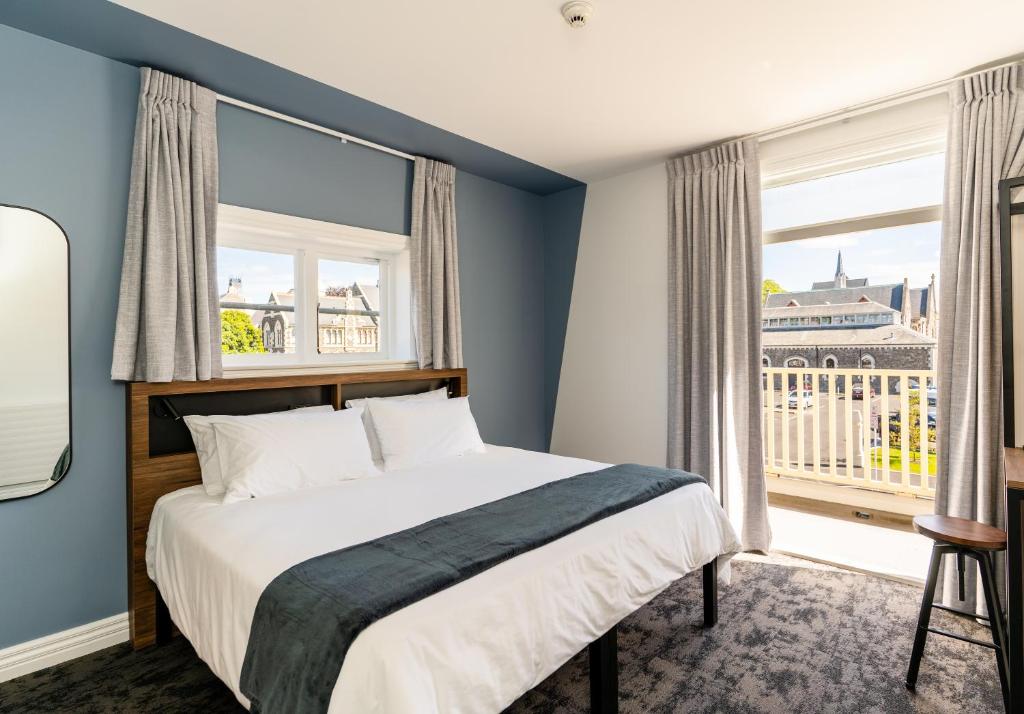 1 dormitorio con cama y ventana grande en Haka House Christchurch, en Christchurch