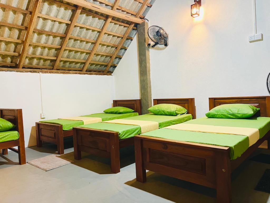 a room with four beds with green cushions at Bay Vista-Yala in Kirinda