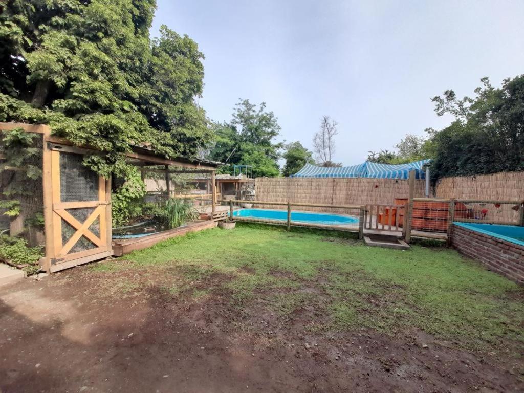 een achtertuin met een zwembad en een hek bij Casa de Huéspedes en Paine in Paine