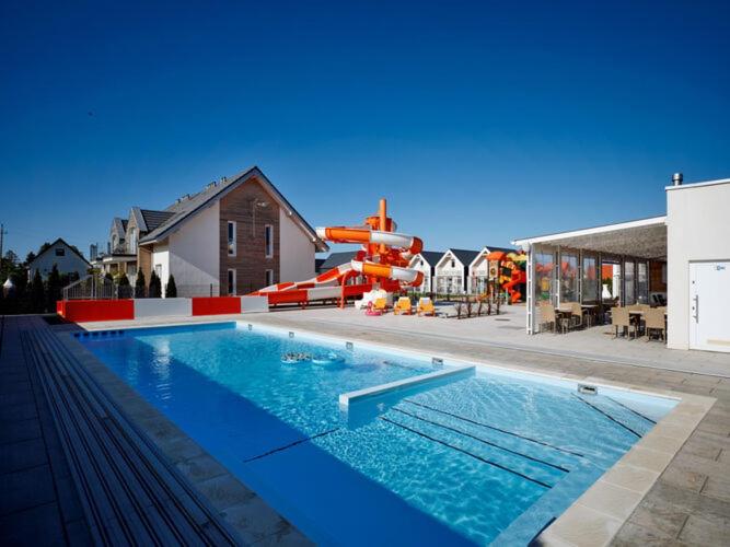 a swimming pool with a water park with a slide at Luxury holiday homes, swimming pool, Sarbinowo in Sarbinowo
