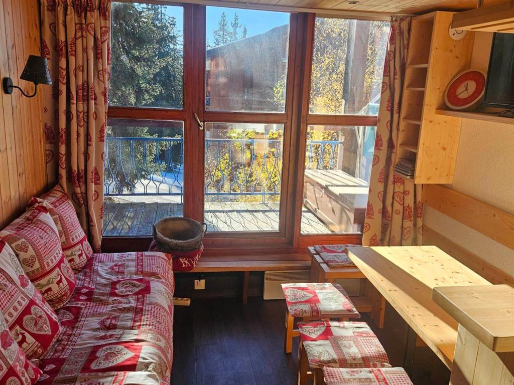 Cette chambre dispose d'un canapé et d'une grande fenêtre. dans l'établissement Appartement duplex 4 pers à Arc 1800, balcon, Wi-Fi, accès pistes et commerces à proximité - FR-1-411-912, à Bourg-Saint-Maurice