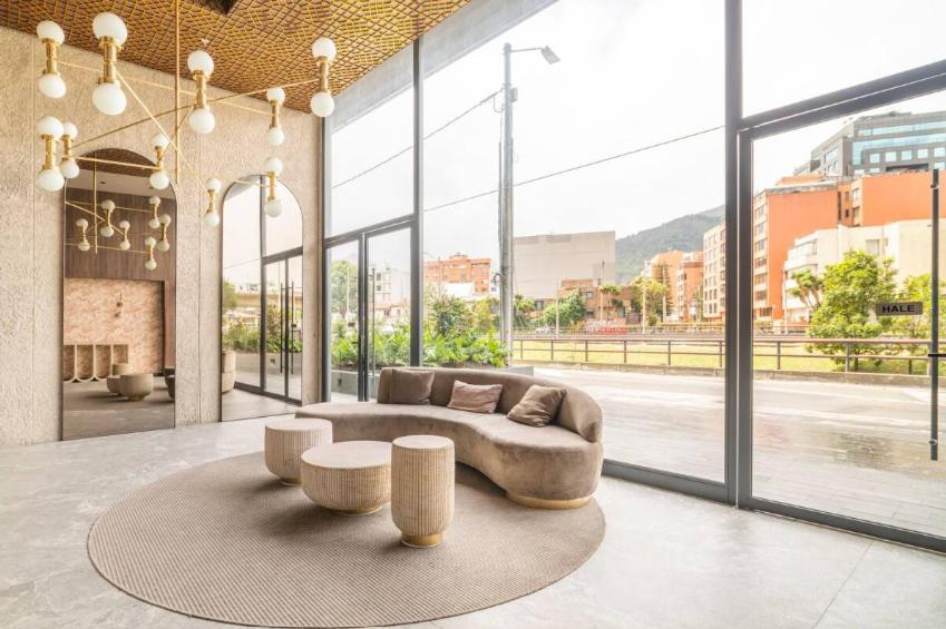 sala de estar con sofá, mesas y ventanas en LUXURY LOFT IN AMAZING BUILDING + POOL, en Bogotá