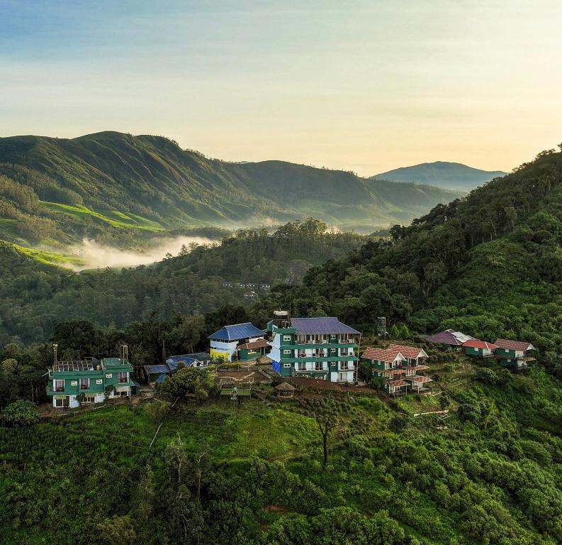a group of houses on a hill in the mountains at Forest County in Munnar