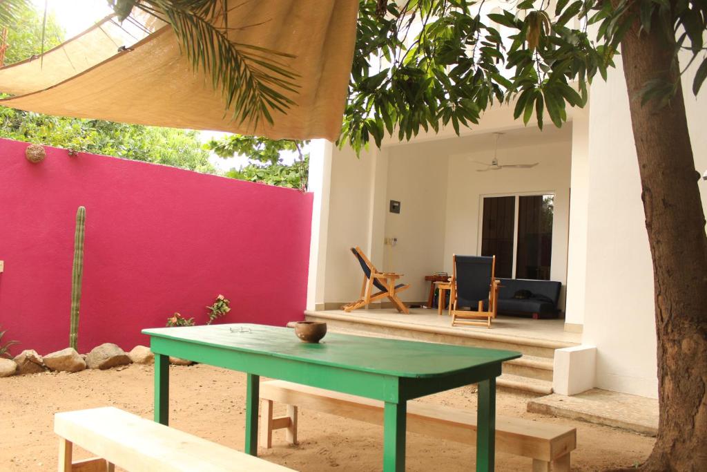 einem grünen Tisch vor einem Haus mit einem Baum in der Unterkunft Mi Puerto Beach Hostel in Puerto Escondido