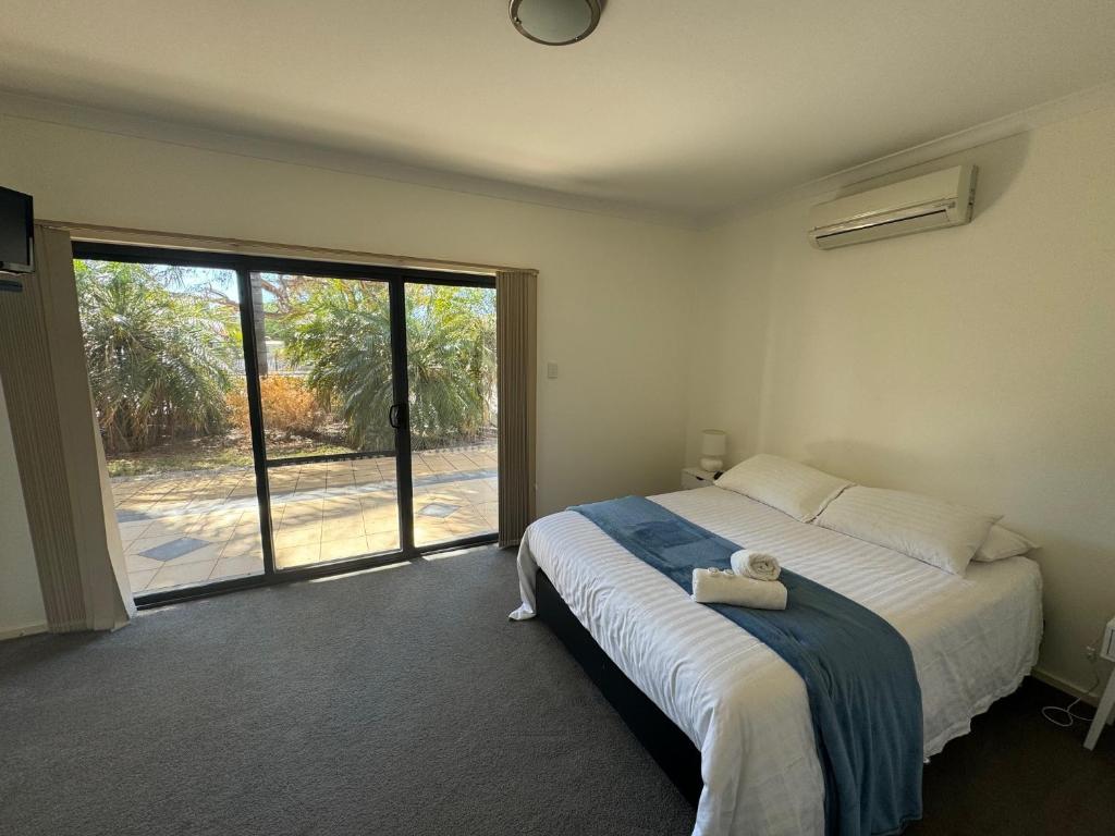 a bedroom with a bed and a large sliding glass door at Cowell Townhouse apartments in Cowell